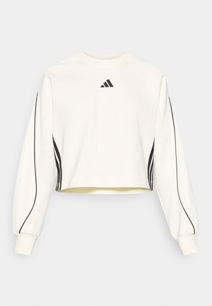 Hvit kortermet sweatshirt med lange ermer, har svarte striper langs sidene og en liten svart logo på brystet. Myk tekstur.