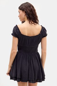 Robe noire à manches courtes avec un corsage smocké, des manches à volants et une jupe évasée. Fabriquée en tissu texturé avec des ourlets superposés.
