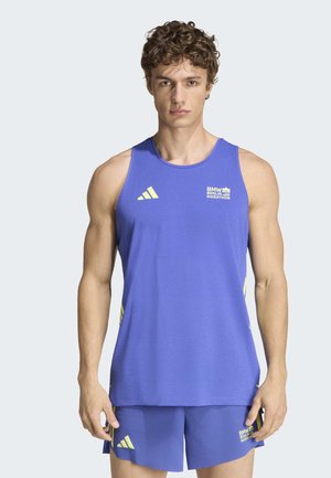 Jeune homme portant un débardeur bleu BMW Berlin Marathon et un short assorti, debout face à l’avant avec une expression neutre.