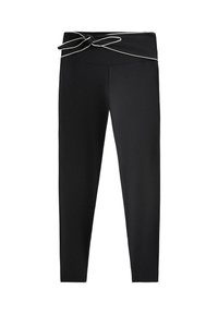 Černé legíny s úzkým střihem a širokým pasem, uvázané mašlí, s bílým lemováním podél okraje pasu.