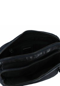 Borsa in pelle nera con chiusura a zip, dotata di molteplici scomparti e una superficie morbida. Interno foderato in tessuto scuro.