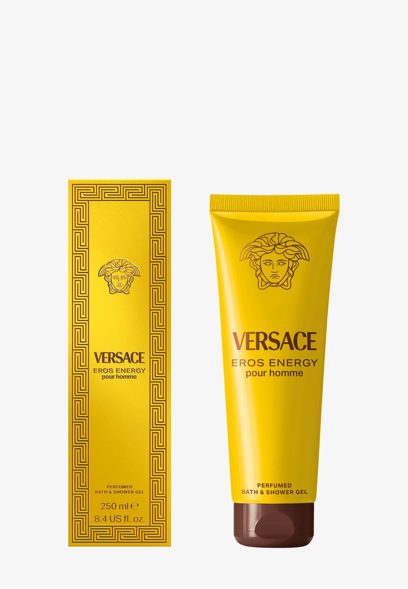 Gel bain et douche Versace Eros Energy dans un tube jaune, présentant un logo Méduse bronze et un bouchon marron, accompagné d'une boîte assortie.