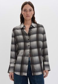 Camicia a quadri bianca e nera con colletto strutturato, maniche lunghe e vestibilità rilassata, realizzata in un tessuto leggero e morbido.