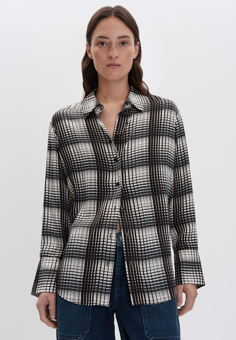 Camicia a quadri bianca e nera con colletto strutturato, maniche lunghe e vestibilità rilassata, realizzata in un tessuto leggero e morbido.