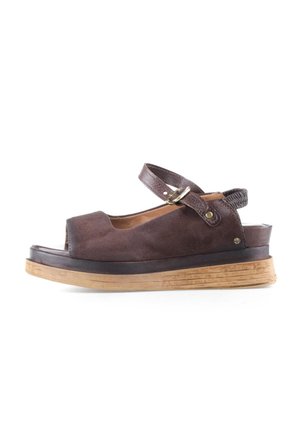 Sandalo aperto in camoscio marrone con cinturino regolabile alla caviglia, suola spessa in legno e tacco leggermente rialzato su sfondo bianco.