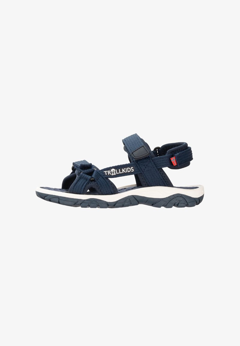 Navy blue children's sandals with adjustable woven straps, textured toe area, cushioned footbed, and sturdy rubber outsole with traction.
