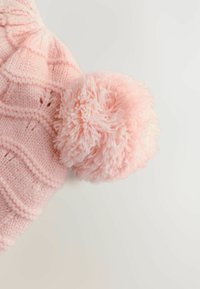 Căciulă tricotată roz cu un model texturat și un pompon mare și pufos în vârf. Materialul pare moale și confortabil.