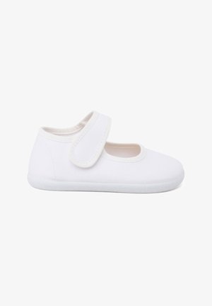 Zapatilla de lona blanca con una textura suave, punta redondeada y correa ajustable de Velcro en el costado. Suela de goma blanca gruesa para soporte.