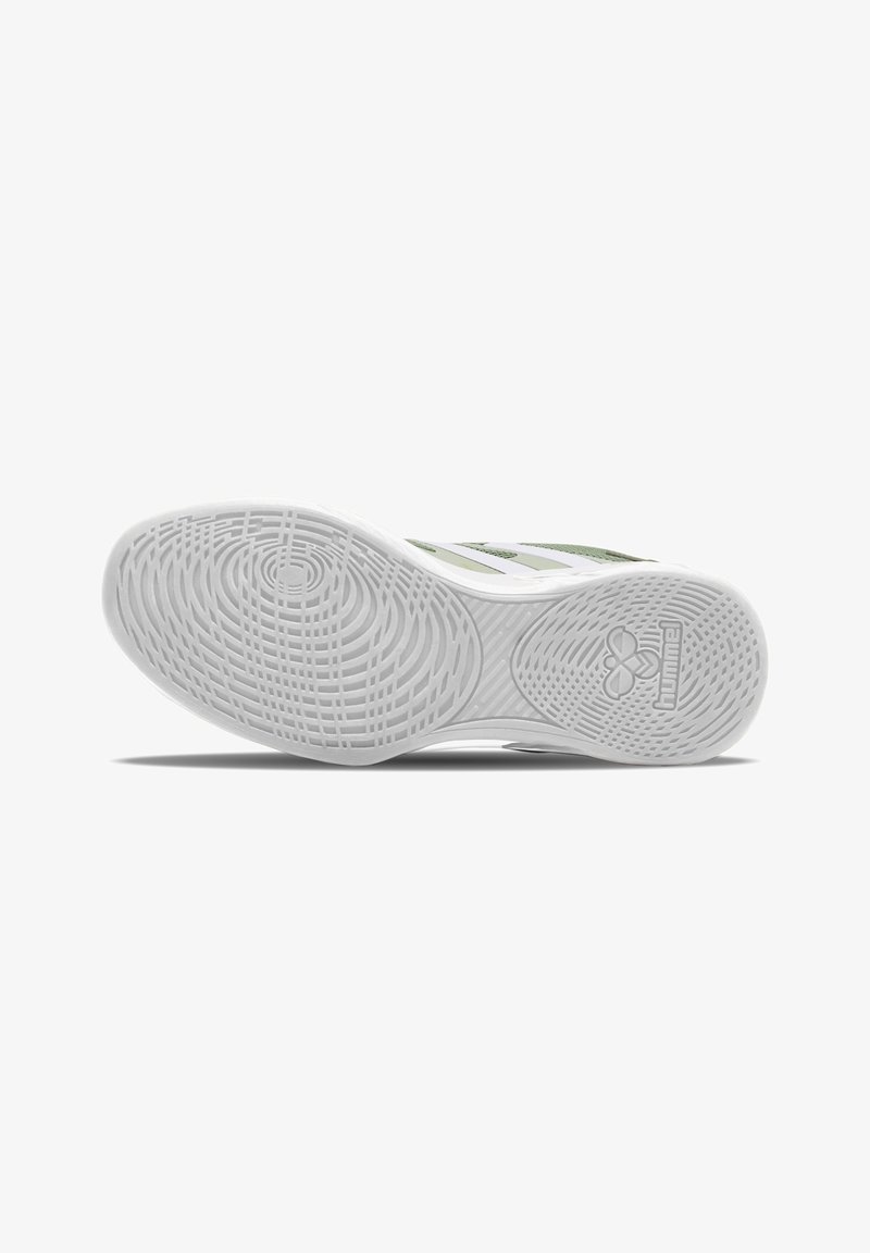 Semelle de chaussure de sport verte et blanche montrant un motif de grip texturé et le logo de la marque sur fond blanc.
