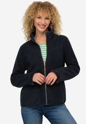 Veste en polaire marine avec un col haut, fermeture éclair et poignets doux. Dotée d'un tirette de fermeture éclair orange et d'une doublure intérieure contrastée.