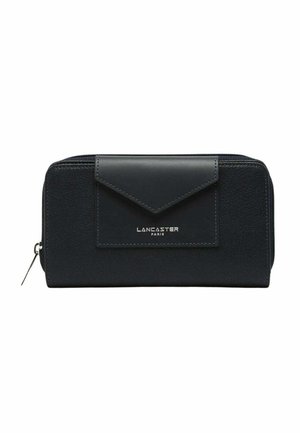 Portefeuille en cuir marine avec une surface texturée et un rabat lisse. Présente un logo argenté, une fermeture éclair et un design angulaire.