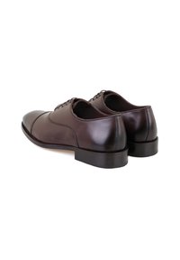 Bruine leren dresschoenen met een gladde afwerking, ronde neus en vetersluiting. De hak en zool zijn plat met een minimale textuur.