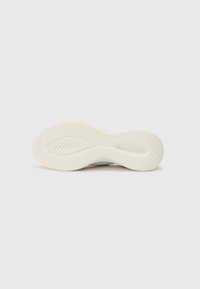 Semelle de chaussure en caoutchouc blanc avec une finition texturée, dotée de motifs de bande de roulement sinueux et de lignes en relief pour une adhérence optimale.