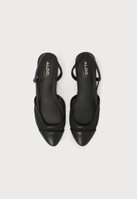 Des chaussures slingback noires en cuir avec des pointes effilées, présentant une surface lisse et des sangles élastiques sur le cou-de-pied. Marquage doré "ALDO" visible.