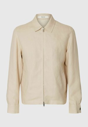 Veste beige à manches longues avec fermeture éclair, col, deux poches latérales et poignets boutonnés.