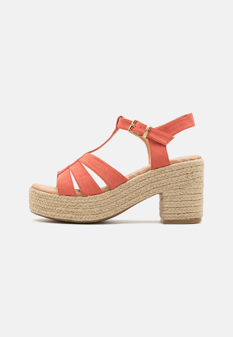 Sandale à talons en suede corail avec plusieurs lanières et boucle de cheville réglable. Plateforme en jute tressé de style espadrille et talon bloc.