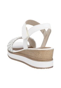 Sandale à plateforme blanche avec une tige tressée, une sangle réglable à la cheville, un talon en liège texturé et une semelle en caoutchouc, présentant un coussin de pied lisse.