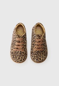 Buty w deseń lamparta mają beżową i brązową tekstylną cholewkę, brązowe sznurówki oraz okrągły czubek i miękką podeszwę.