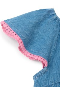 Prenda de mezclilla con un borde de ganchillo rosa. Presenta mangas cortas, una textura suave y un color azul clásico. Costuras detalladas visibles.