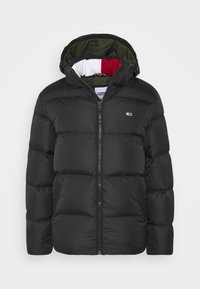 Zwarte pufferjack met een ritssluiting aan de voorkant, voorzien van een capuchon, groene binnenvoering en een klein logo op de borst. Gequilt ontwerp met textuur.