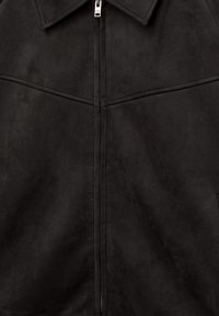 Giacca nera in finta suede con chiusura a zip, colletto a punta e tessuto testurizzato. Cuciture in evidenza e design minimalista senza ulteriori decorazioni.