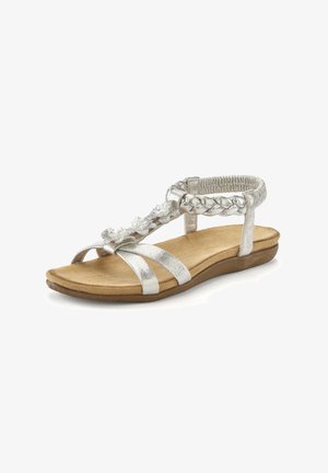Silver flat sandal with braided ankle strap and decorative accents. Textured straps and cushioned footbed with a light brown sole.