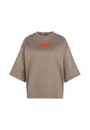 T-shirt marron surdimensionné en coton doux, avec un col rond et des manches courtes. Logo rouge remarquable imprimé sur le devant.