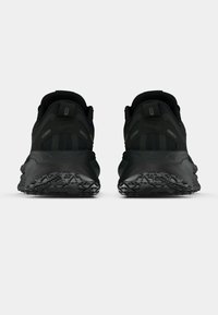 Mustad mustat spordijalatsid, millel on kaks tagumist tõmbeahelat, tekstuuriga mesh ülemine osa, struktureeritud kandetoed ja jäik must kummist välispind haardeks.