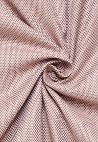 Tessuto testurizzato con un motivo geometrico a diamante in rosa pallido e bianco, caratterizzato da dettagli raffinati e superficie liscia.