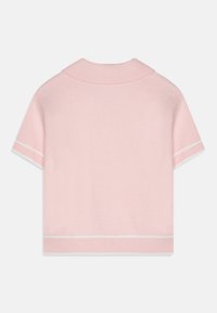 Kortermet, lys rosa strikkegenser med krage og hvite ribbede detaljer ved kanten og ermene. Myk tekstur.