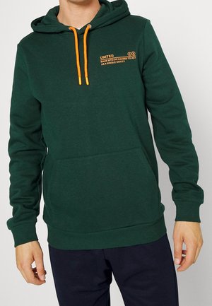 Sudadera verde hecha de una tela suave, con cordón ajustable en naranja, bolsillo frontal y texto impreso en el lado izquierdo del pecho.