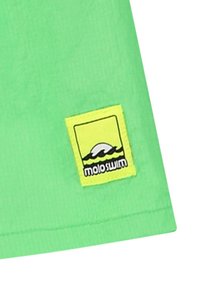 Tessuto da bagno verde con una toppa in nero e giallo che presenta onde. La toppa è rettangolare con testo chiaro e elementi di design grafico.