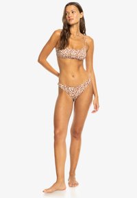 Bruin bloemenprint bikini met een aansluitende crop top en low-rise broekjes. Verstelbare bandjes en een zachte stof.