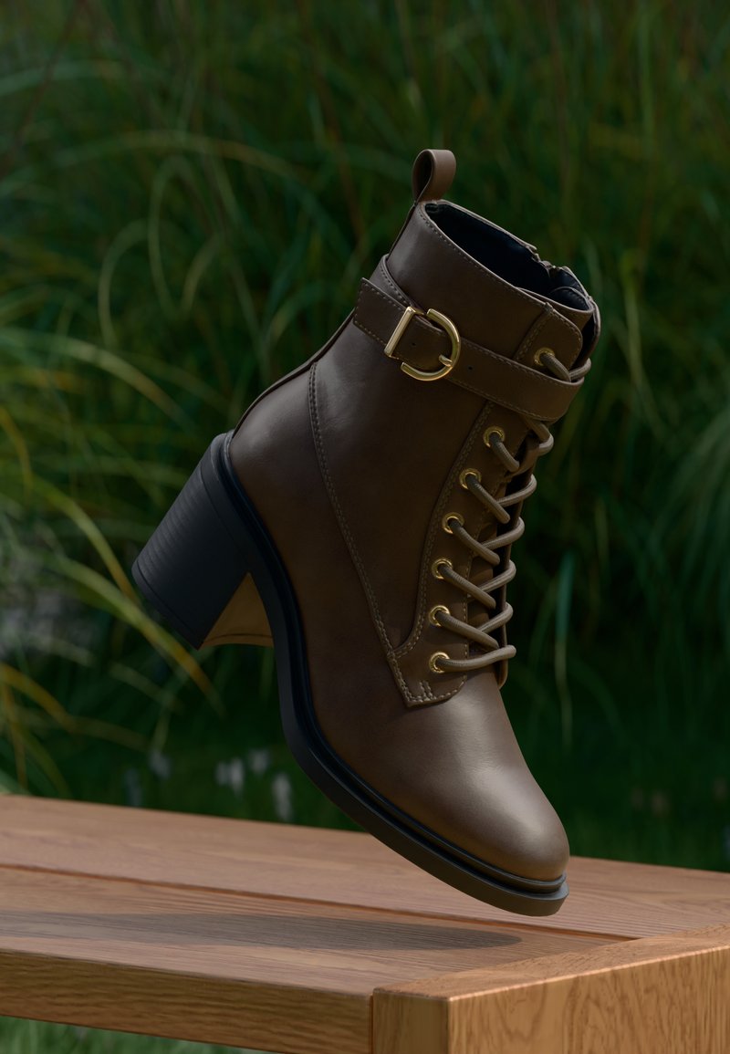 Botín de cuero marrón hasta el tobillo con un tacón grueso, acentos metálicos, diseño de cordones y una correa lateral con una hebilla dorada.