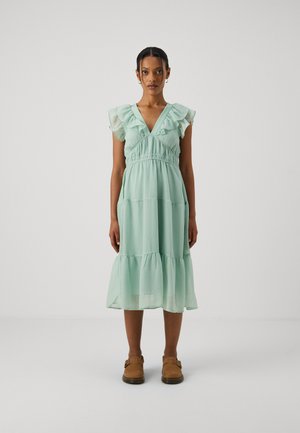 Light mint green, tiered dress with ruffled short sleeves, V-neck, and gathered waist. Lightweight fabric, hem falls below the knee.