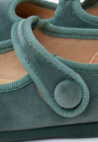 Žalio aksomo Mary Jane stiliaus batai su apvalia nosimi, reguliuojama juosta su audinio mygtuku ir minkšta vidine pamušalu.