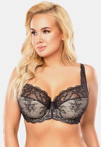 Reggiseno in pizzo nero caratterizzato da un design semi-trasparente con motivi floreali, bordi scallop, coppe lisce e spalline regolabili.