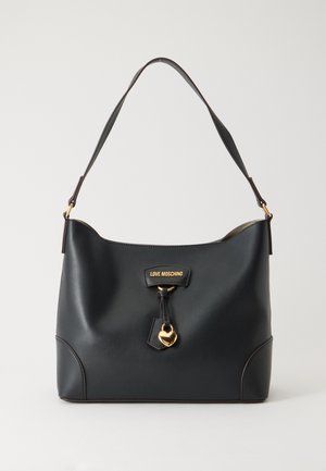 Sort læder Love Moschino håndtaske med skulderrem, guldfarvet hjertecharm og logo-plakette foran mod en ensfarvet baggrund.