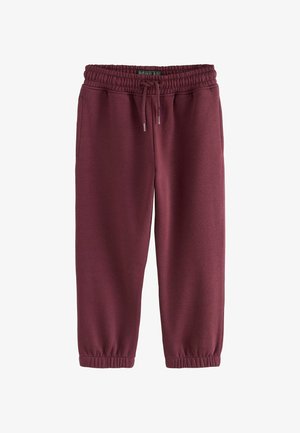 Bordeaux jogger broeken met elastische tailleband en trekkoord, zijzakken en elastische mouwen, plat gelegd op een witte achtergrond.