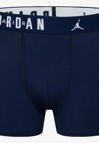 Dunkelblaue Boxershorts aus Baumwolle. Ausgestattet mit einem weißen elastischen Bund mit der Aufschrift „JORDAN“ und dem Logo. Glatte Textur mit figurbetontem Design.