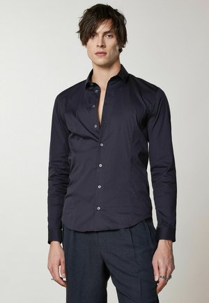Camicia a maniche lunghe blu navy in tessuto liscio con colletto, abbottonatura frontale e vestibilità sartoriale. Presenta una leggera lucentezza e polsini.