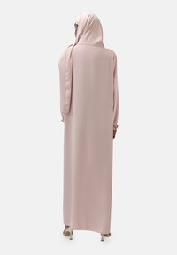 Abaya lunga rosa con una texture liscia e fluida, caratterizzata da maniche lunghe e un hijab coordinato, progettata per la modestia e l'eleganza.