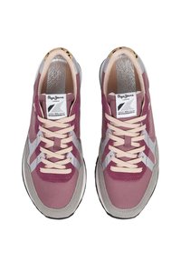 Lilla ja halli tenisekingad, millel on tekstureeritud disain, beežid paelad ja bränditud keeletag. Talda on musta värvi valge äärega.