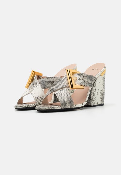 Sandales à talons blocs à lanières croisées, en simili cuir serpent texturé, avec une boucle dorée et une palette de couleurs neutres.