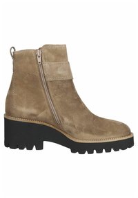 Stivale alla caviglia in suede beige con zip laterale, caratterizzato da una suola in gomma nera larga e chunky e un semplice dettaglio con cinturino vicino alla caviglia.