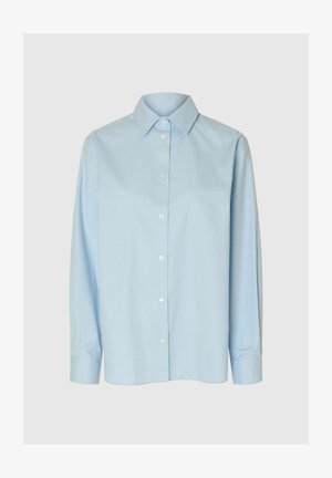 Světle modrá košile na knoflíky vyrobená z hladké tkaniny, s klasickým límcem, dlouhými rukávy a rovnými lemy, doplněná o bílé knoflíky.