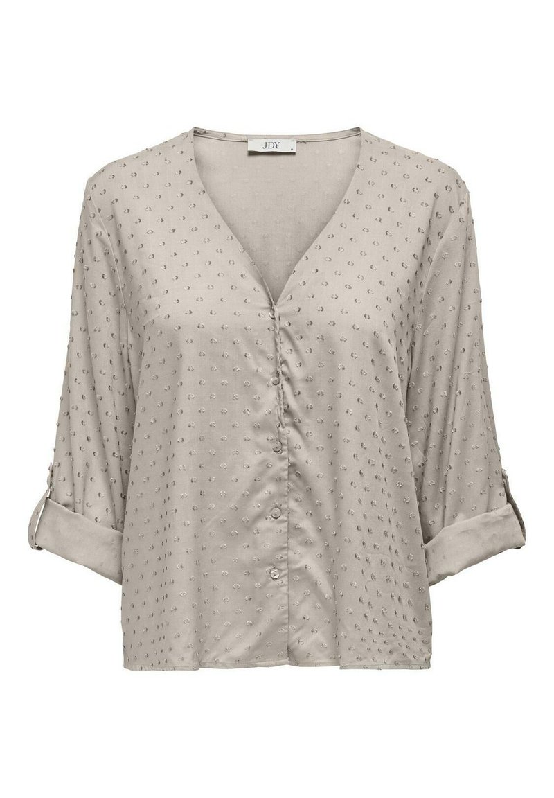 Blusa beige chiaro con scollatura a V, maniche a tre quarti, dettagli con bottoni e tessuto testurizzato caratterizzato da piccoli punti in rilievo.