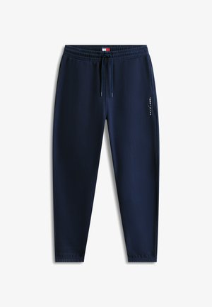 Marineblauwe joggingbroek met elastische tailleband en trekkoord, zijzakken, elastische boorden en wit "Tommy Jeans" logo op de rechterdij.