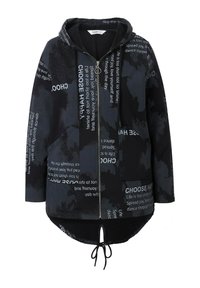 Sudadera con cremallera negra y dobladillo ajustable con cordón, que presenta un tejido texturizado y frases impresas en varias fuentes a lo largo de la superficie.