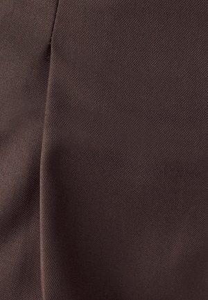 Brūns audums ar gludu tekstūru un smalku diagonālu aušanas rakstu, ar vieglu krāsojumu un mīkstām krokām.